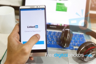 Man Hand Holding  Android Device With Linkedin On The Screen Stock Photo