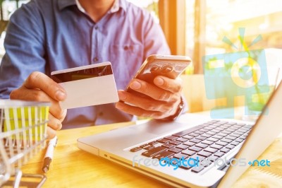 Man Holding Credit Card In Hand And Entering Security Code Using… Stock Photo