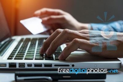 Man Holding Credit Card In Hand And Entering Security Code Using… Stock Photo