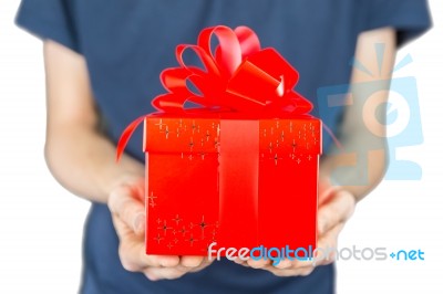 Man Holding Red Christmas Gift In Front Of Body Stock Photo