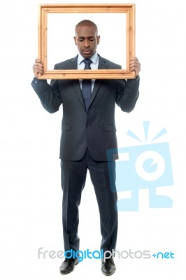 Man Holding Wooden Picture Frame, Looking Down Stock Photo