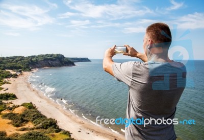 Man In A Gray T-shirt Photographing Seascape Stock Photo