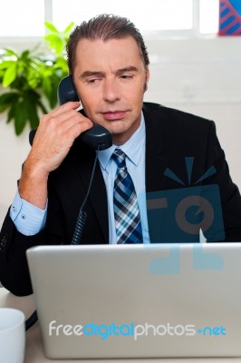 Man In Formal Attire Talking On The Phone Stock Photo