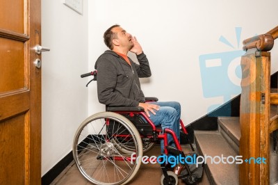 Man In Wheelchair Facing A Barrier Of Stairs Stock Photo