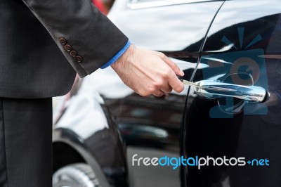 Man Inserting Car Key Into The Door Lock Stock Photo