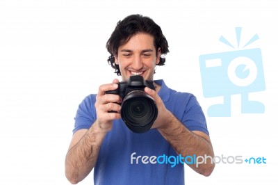 Man Looking At Pictures Stored In Camera Stock Photo