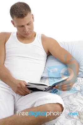 Man Lying On Bed And Reading Book Stock Photo