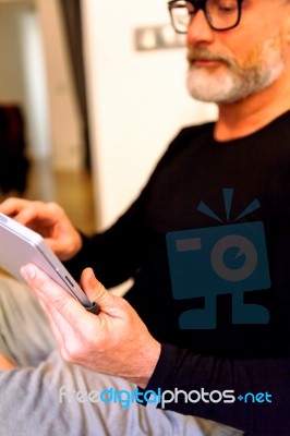 Man Middle-aged Browsing Through His Tablet Stock Photo