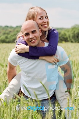 Man Piggybacking Her Girlfriend Stock Photo