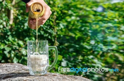 Man Pouring Beer From A Jar Into A Mug Stock Photo