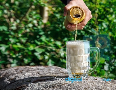 Man Pouring Beer From A Jar Into A Mug Stock Photo