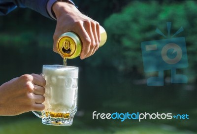 Man Pouring Beer From A Jar Into A Mug Stock Photo