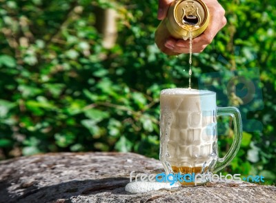 Man Pouring Beer From A Jar Into A Mug Stock Photo