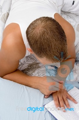 Man Reading Book While Resting Stock Photo