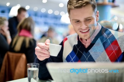 Man Reading Newspaper At Outdoor Cafe Stock Photo