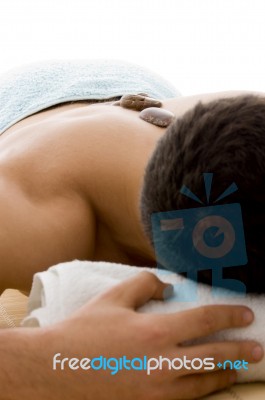 Man Relaxing With Stone Treatment Stock Photo