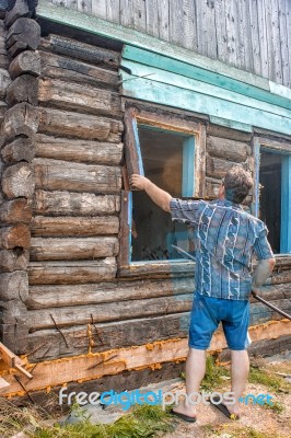 Man Repairing A Wooden House Stock Photo