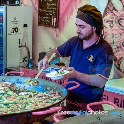 Man Selling Paella On A Market Stall In Bergamo Stock Photo