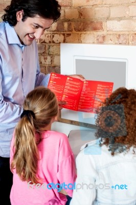 Man Showing Daughters How To Order Pizza Online Stock Photo