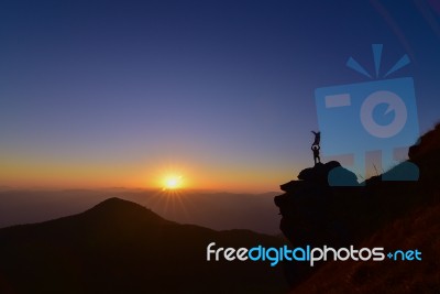 Man Standing On The Rock On Top Of The Mountain Stock Photo