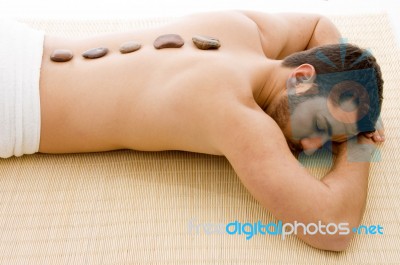 Man Taking Hot Stone Treatment Stock Photo