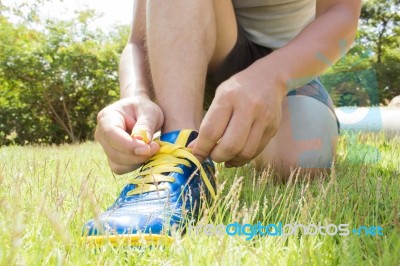 Man Tying Shoes On Green Grass Stock Photo