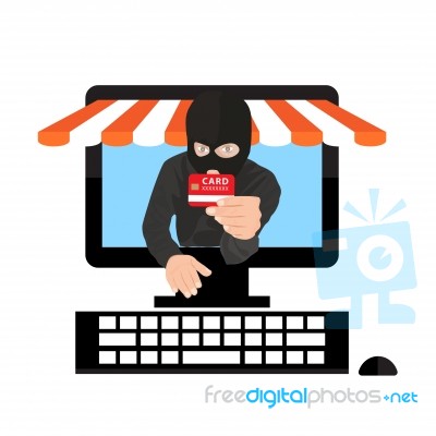 Man Wearing Balaclava And Holding Credit Card While Using Laptop At Desk Stock Image