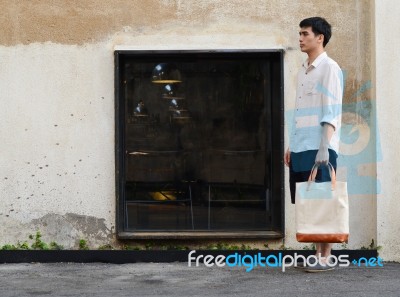 Man With Canvas Bag On Grunge Concrete Background Stock Photo