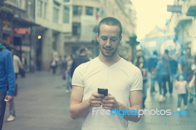 Man With Cell Phone Walking On Street Stock Photo