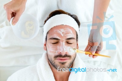 Man With Clay Facial Mask In Beauty Spa Stock Photo