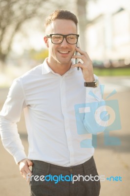 Man With Glasses Speak On Mobile Phone In Hands Stock Photo