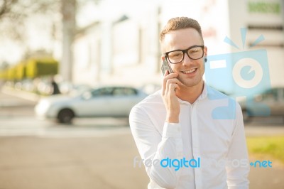 Man With Glasses Speak On Mobile Phone In Hands Stock Photo