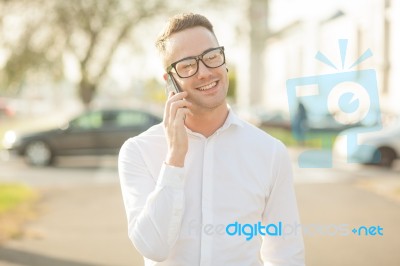 Man With Glasses Speak On Mobile Phone In Hands Stock Photo