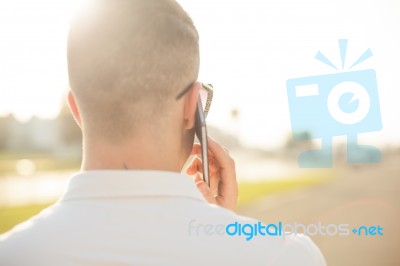 Man With Mobile Phone In Hands, Back View, Outdoor Stock Photo