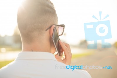 Man With Mobile Phone In Hands, Back View, Outdoor Stock Photo