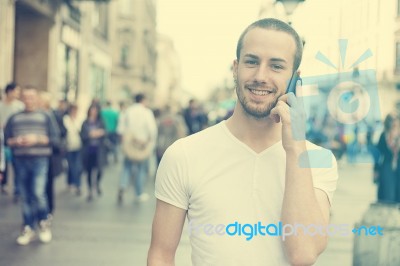 Man With Mobile Phone Walking On Street Stock Photo