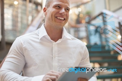 Man With Tablet Computer In Modern Business Building Stock Photo