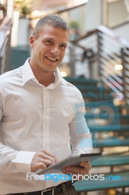 Man With Tablet Computer In Modern Business Building Stock Photo