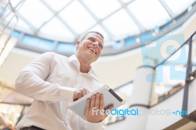 Man With Tablet Computer In Modern Business Building Stock Photo