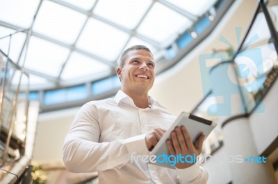 Man With Tablet Computer In Modern Business Building Stock Photo