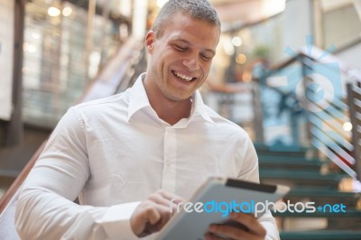 Man With Tablet Computer In Modern Business Building Stock Photo