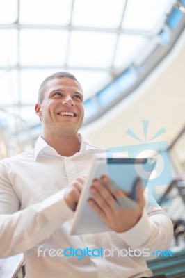 Man With Tablet Computer In Modern Business Building Stock Photo