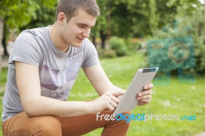 Man With Tablet Computer In Park Stock Photo