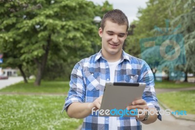 Man With Tablet Computer Relax In Park Stock Photo