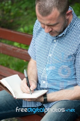 Man Writing In Notepad Stock Photo