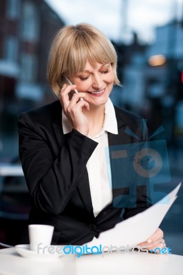 Manager Communicating Via Cell Phone In Cafe Stock Photo