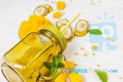 Mango And Banana Smoothie In Mason Jar With Straw Stock Photo