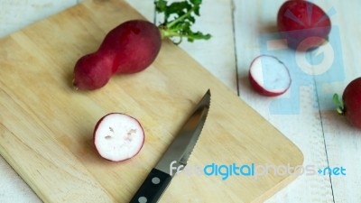 Many Radishes With Knife On The Chopping Board Stock Photo