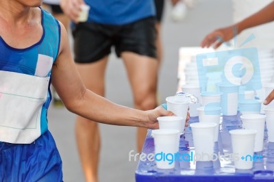 Marathon Racer Catching Cup Of Water Stock Photo