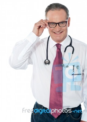 Mature Doctor Removing Specs Stock Photo